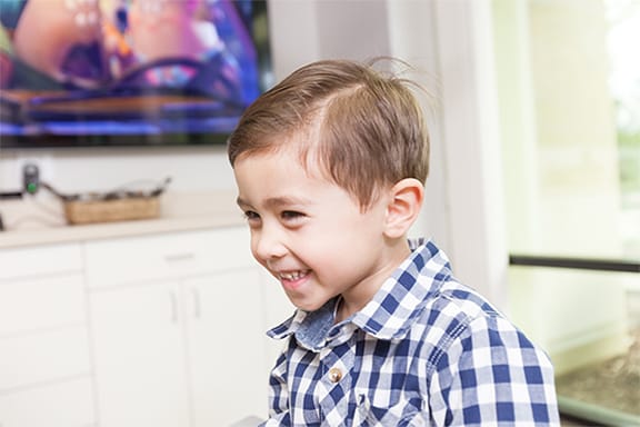 Young kid sitting in dental chair smiling