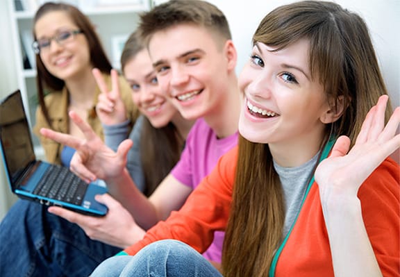 Young adults with laptop looking at the camera and smiling